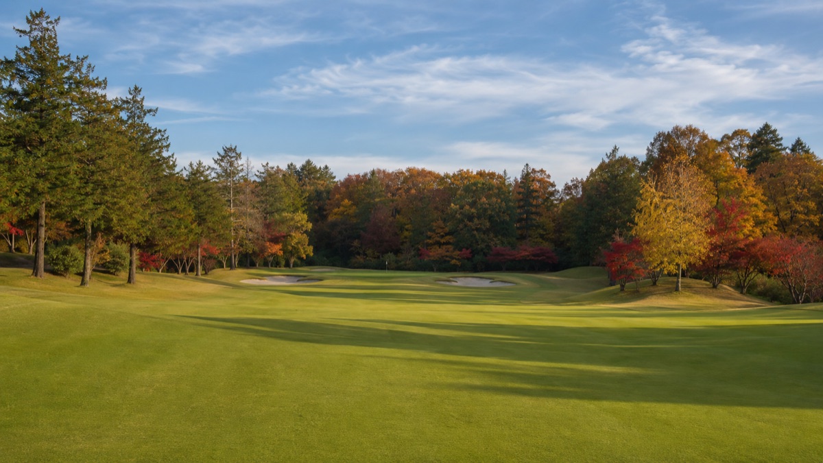 紅葉に囲まれた秋のゴルフコースのフェアウェイとグリーン｜10月・11月のコースデビューシーズン