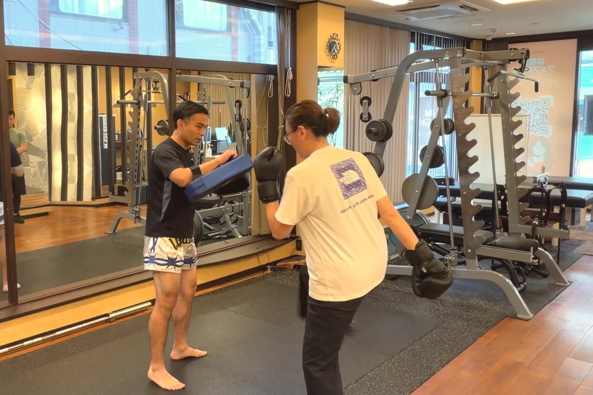 トレーナーが構えるミットに蹴りを入れる参加者