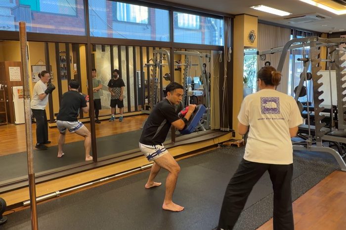 トレーナーが構えるミットを蹴る参加者