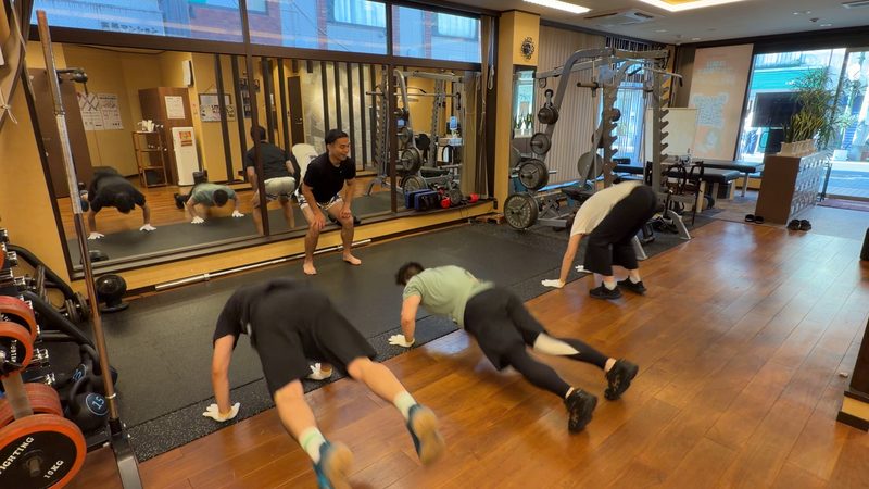 マットの上でサーキット式のエクササイズをする参加者