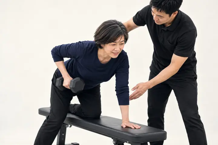 フォームを見てもらいながらトレーニングする女性